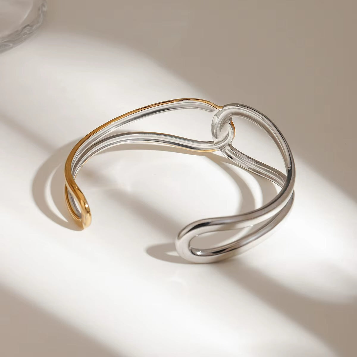 Brazalete acero inoxidable en oro de 18 quilates con nudo geométrico